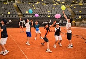 Kinder beim Tennistraining üben Koordination mit Luftballons